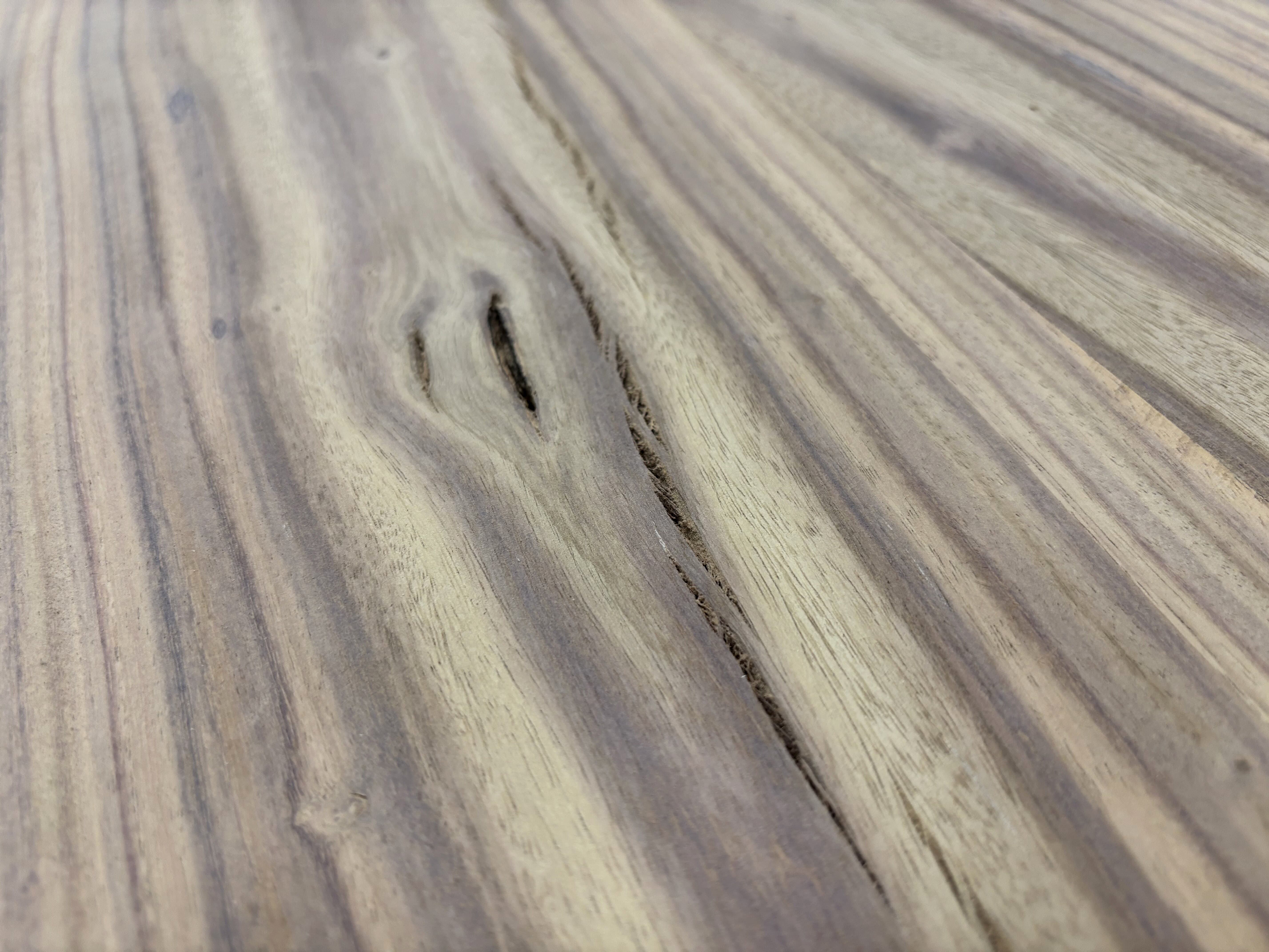 A fine hairline crack traced through the grain