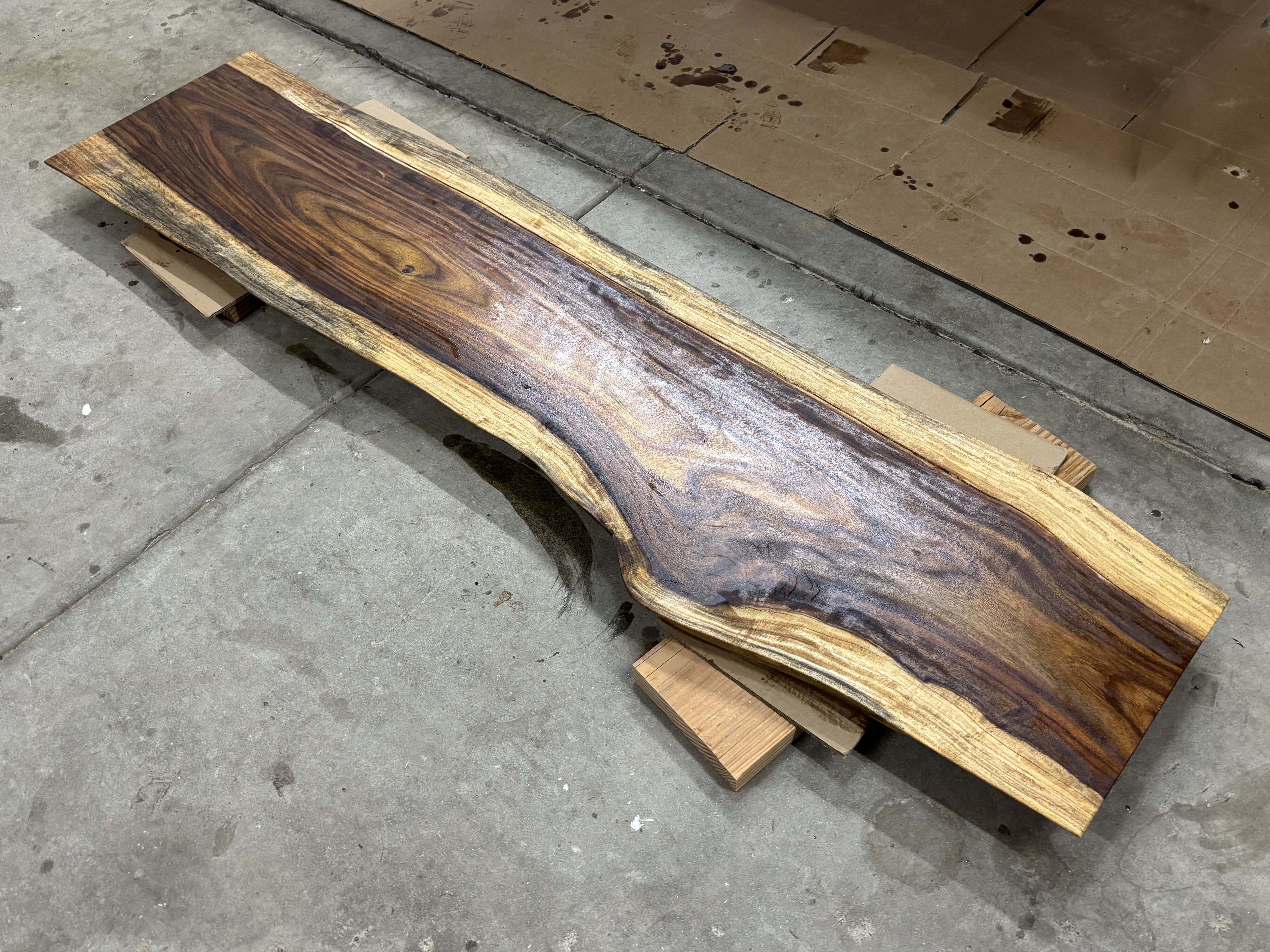 A single board with its clear seal coat glossed and curing